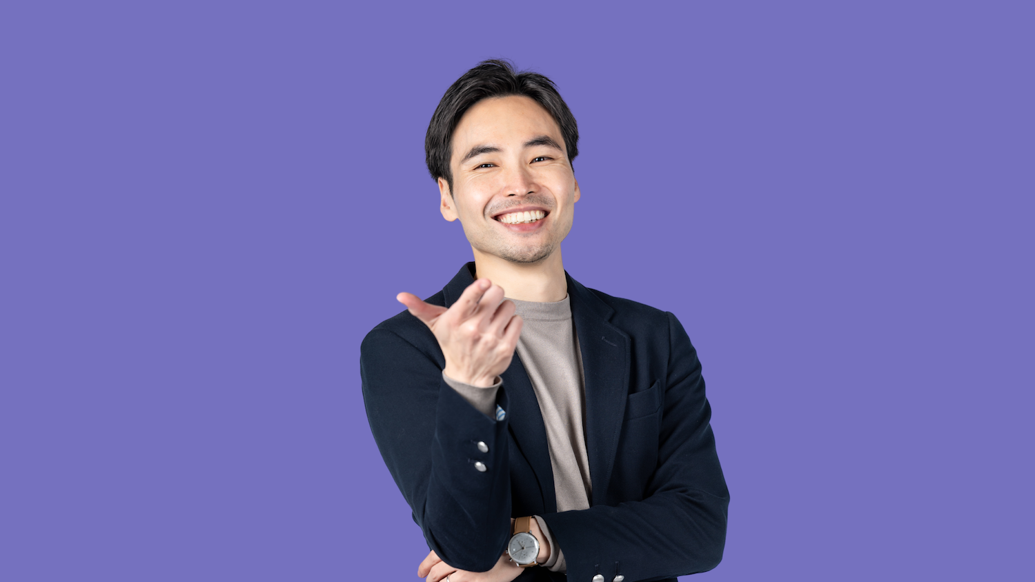 Man pointing, wearing a blazer, on a purple background.