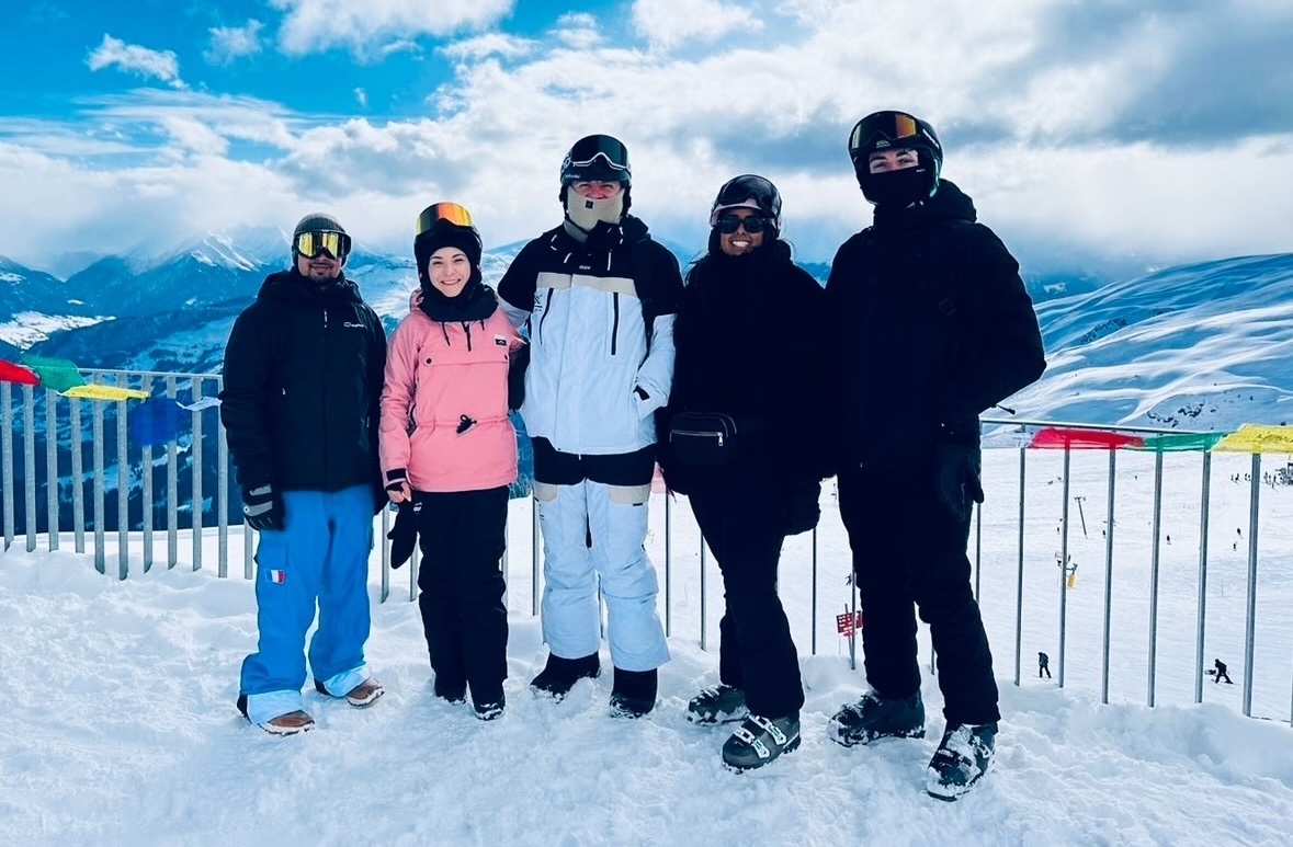 Group of people in ski gear posing in the snow.