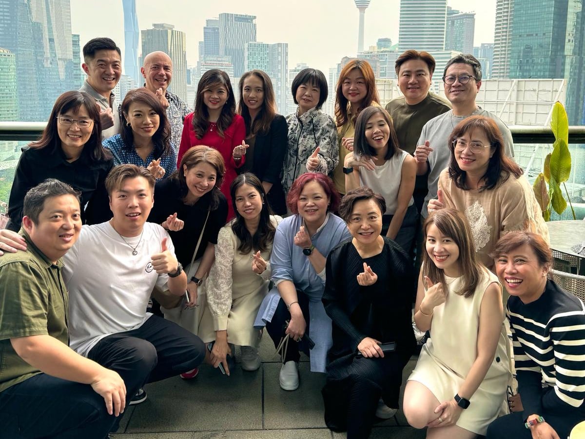 Group of people posing for a photo with a city backdrop.