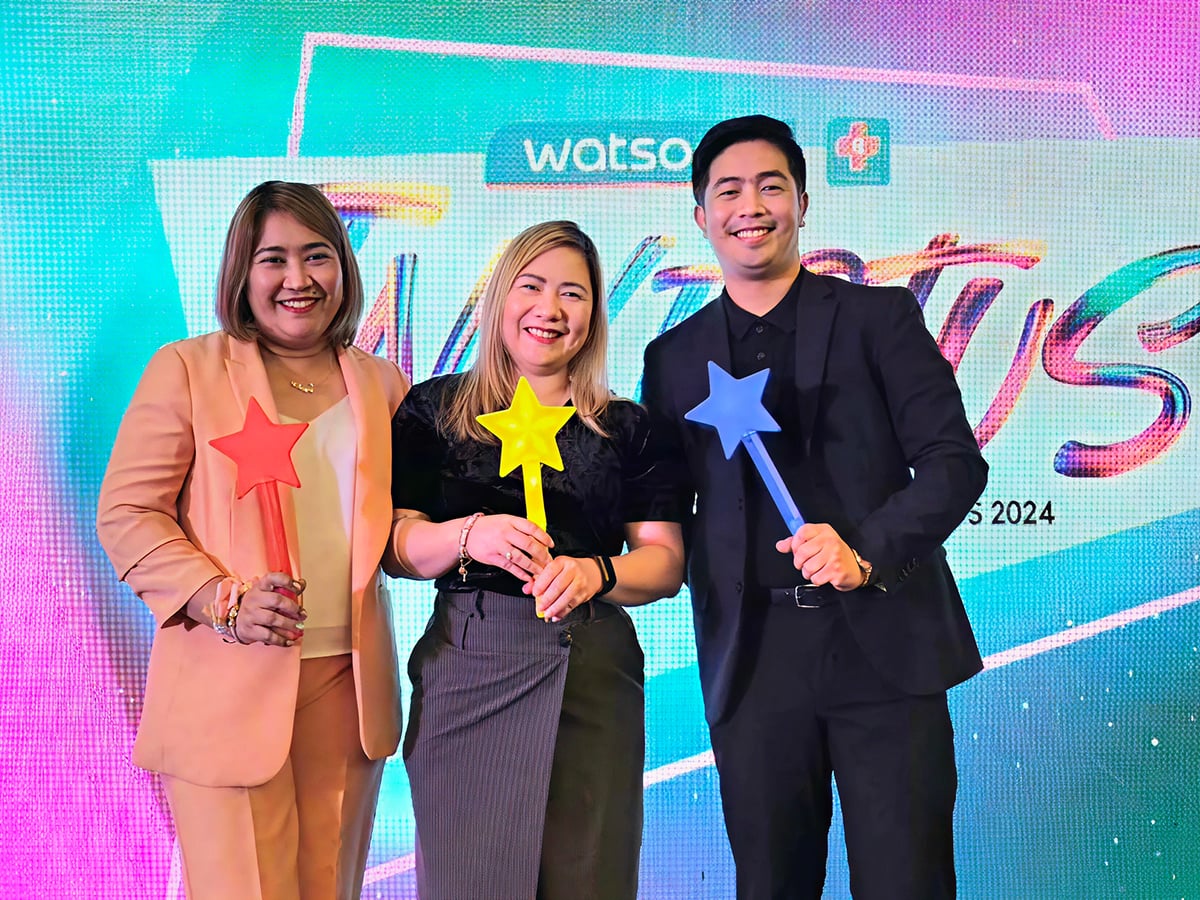 Three people holding star wands, smiling.