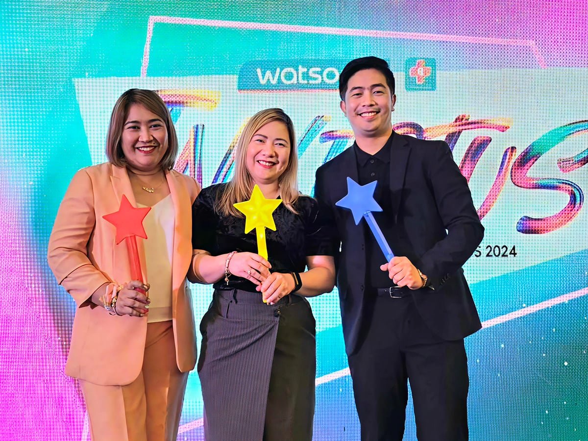 Three people holding star wands, smiling.