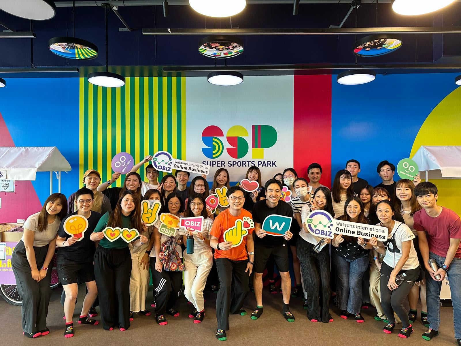 Group of people holding signs, smiling, and posing for a photo.