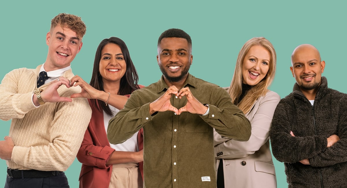 Group of people smiling, making heart shapes with their hands.