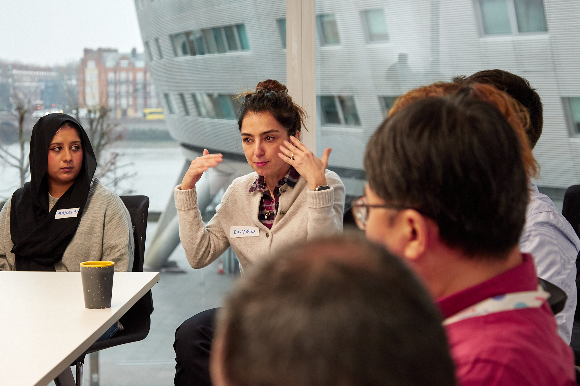 People in a meeting, gesturing and talking.