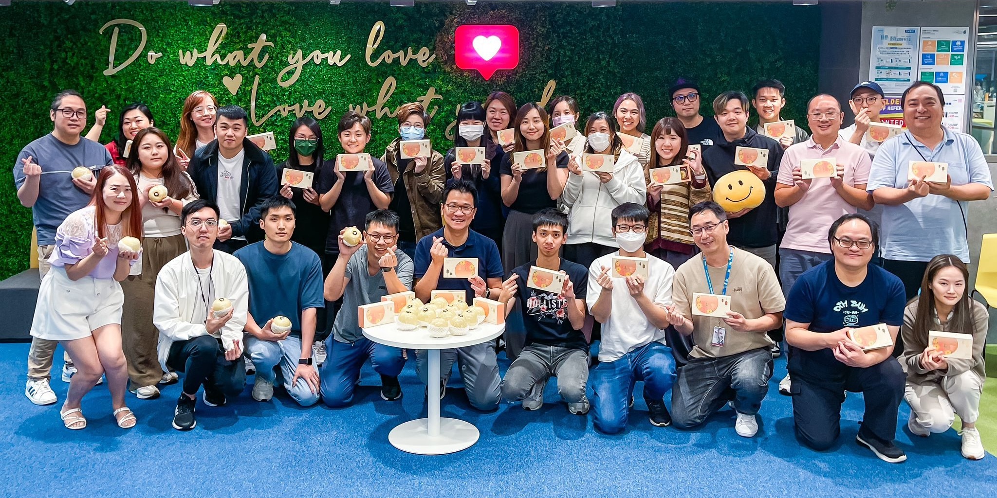 Group of people holding gifts, smiling, and posing for a photo.