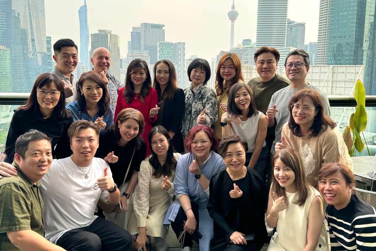 Group of people posing for a photo with a city skyline in the background.
