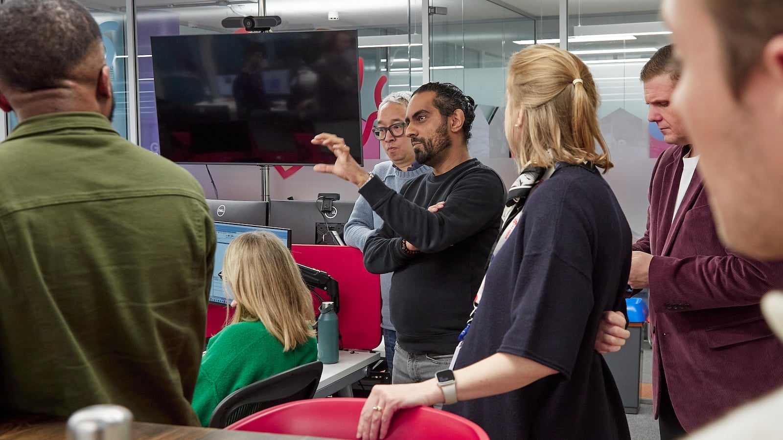 People in an office setting, discussing something.