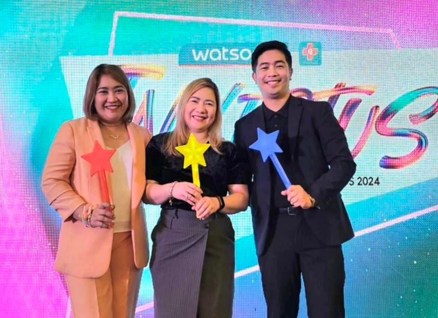 Three people holding star wands at an event.