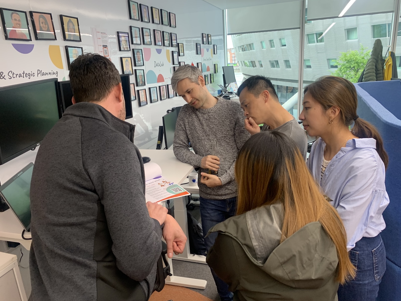 Group of people in an office setting, discussing.