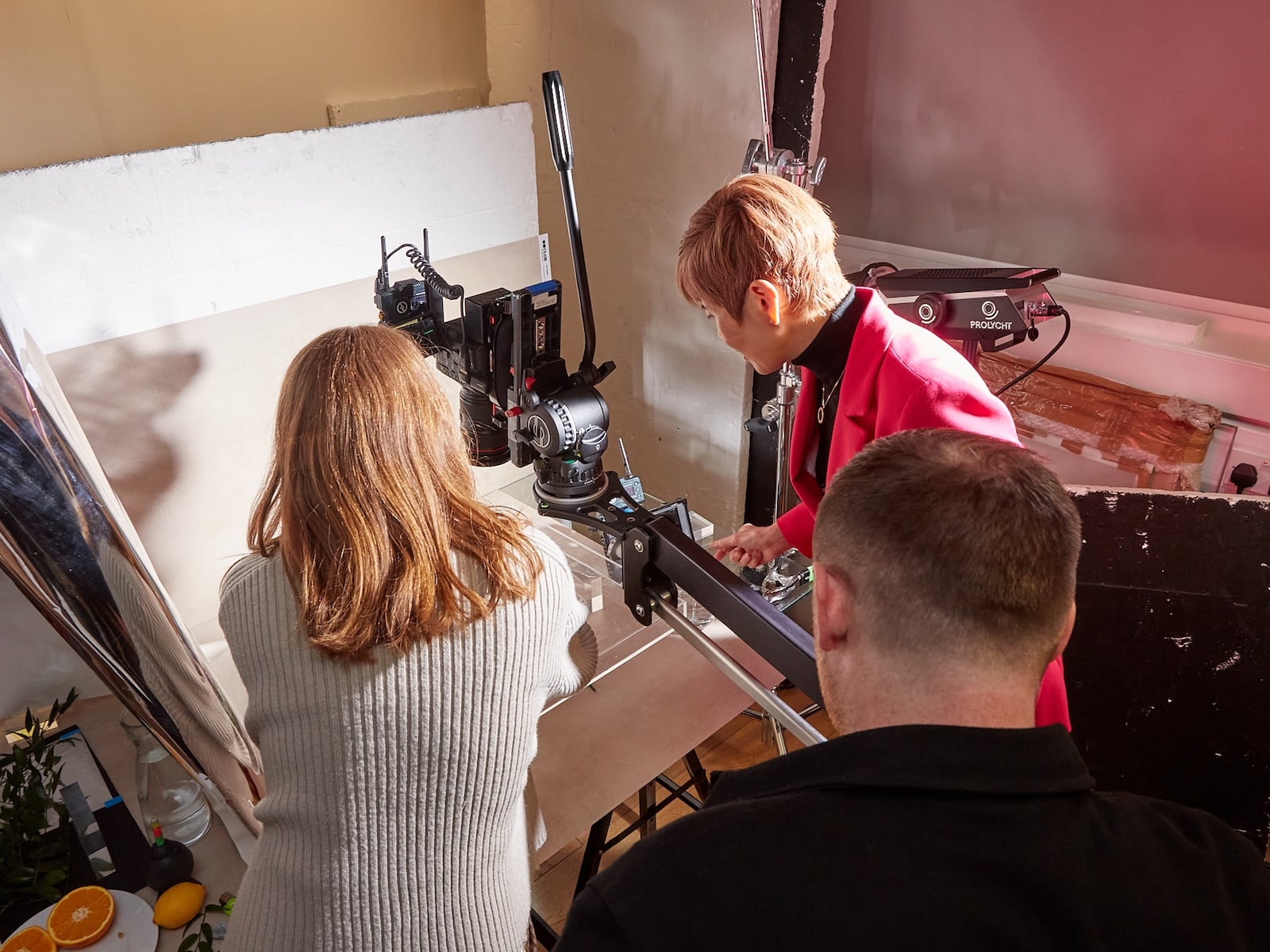 People working on a commercial set with a camera and lights.
