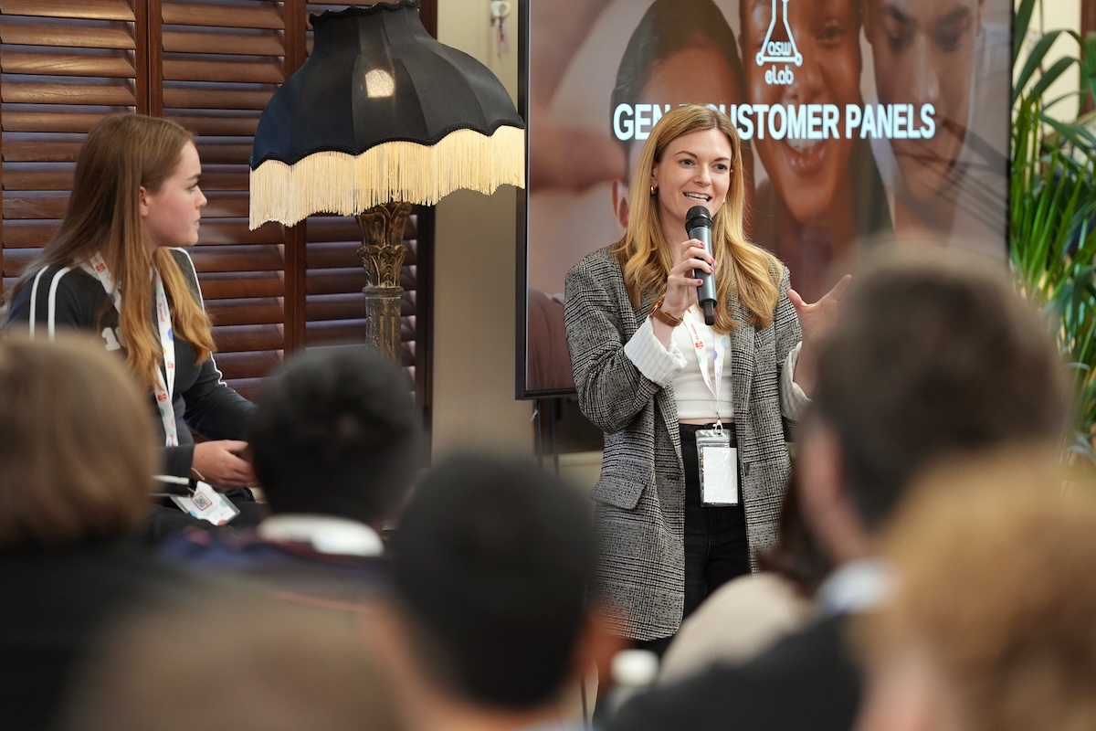 Woman with microphone speaking at a conference, panel discussion.