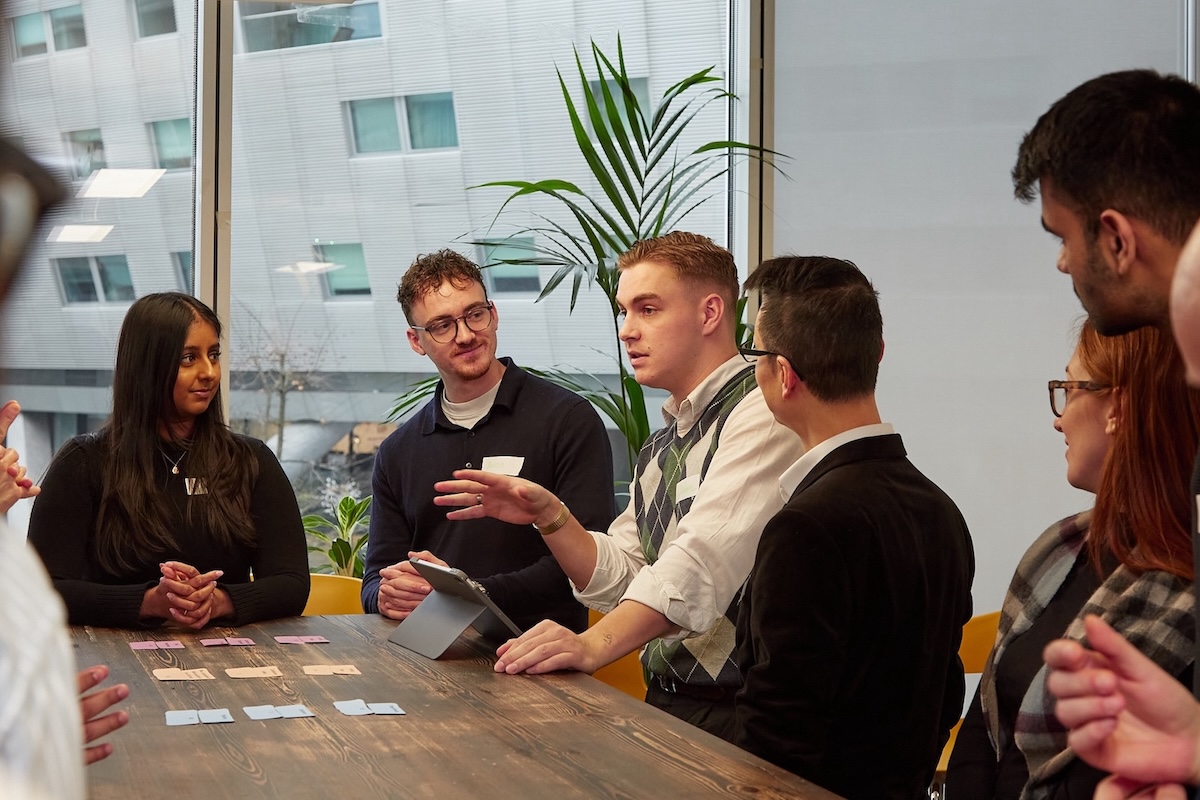 People at a table, discussing cards.
