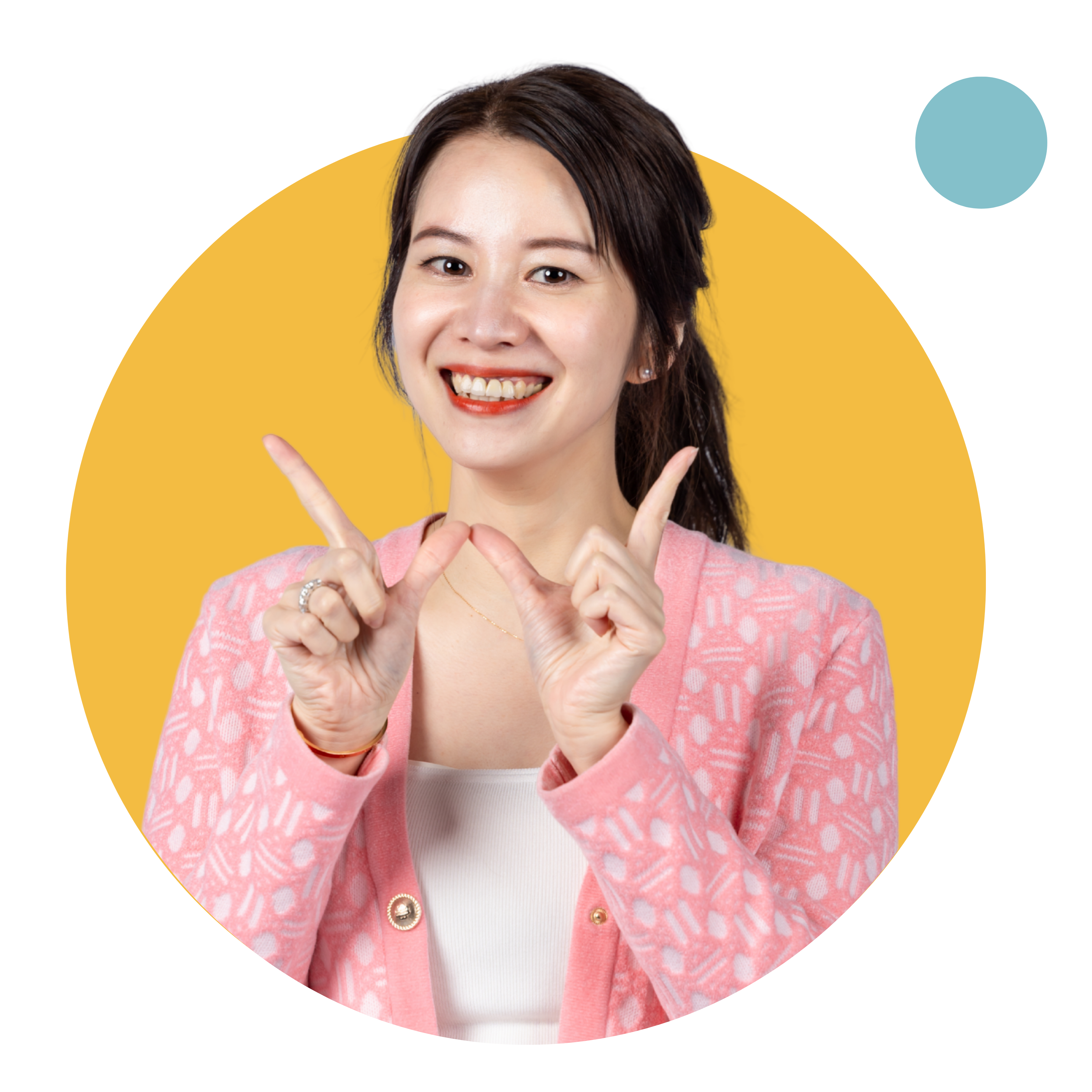 Woman smiling, wearing pink sweater, pointing fingers.